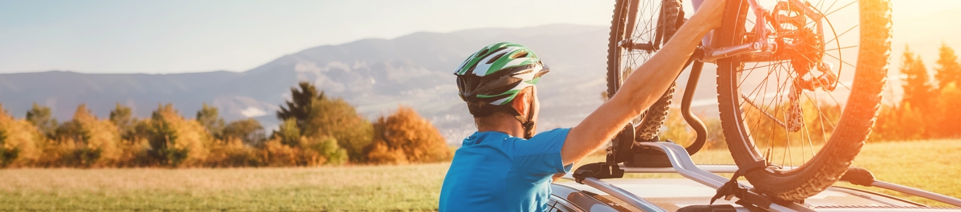 man fitting cycle to top of car